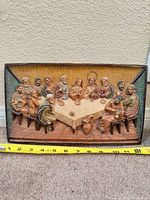 Full view of rectangular hand-painted relief plaque with measuring tape for scale