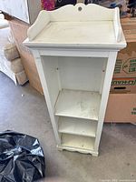 Front view showing three shelves and scalloped top