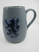 Front of stoneware mug with lion relief