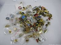 Wide view of entire assortment of city and town pins spread on table, some in plastic sleeves