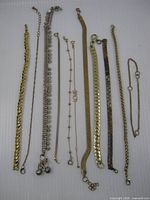 All 11 bracelets laid out side by side showing variety of link styles and clasps