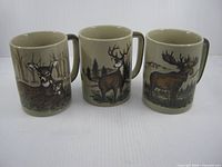 Front view of all three mugs showing different wildlife designs