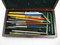 Pens and pencils in a wooden box
