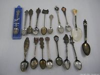 Group shot of all 17 souvenir spoons including cased Stuart example