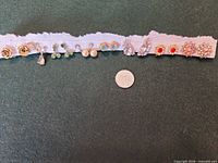 Front view of all 12 earring pairs alongside a coin for scale