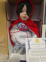 Doll in box with bubble wrap, showing costume and hood