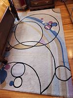 Full view of first rug showing abstract circle motif and stripe accents
