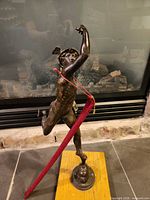 Full view of Hermes statue on wood plaque in front of fireplace