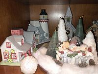 Overall view showing ceramic houses, snowman figurine, green cone candles, cotton snow, snowball candle