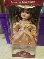 Front view of boxed Donnatella De Roma porcelain doll with clear window showing doll and attire