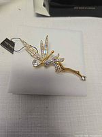 Full view of gold-tone fairy brooch on display pad