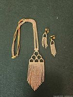 Necklace and matching earrings laid flat showing full design