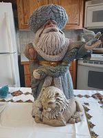 Front view showing full Santa figurine, dove on hand, lion at base