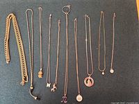Group shot of all 11 necklaces laid out to show variety, colours and pendants