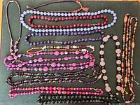All necklaces arranged flat showing colors, bead shapes, and clasp types