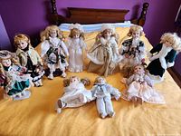 Group shot of all eleven dolls on bed