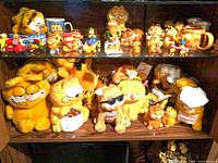 Shelving with Garfield plush toys, mugs, cookie jar, assorted figurines