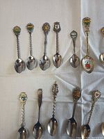 Group of souvenir spoons with enamel crests and floral bowls