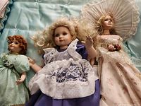 Three dolls laid side by side showing full outfits and relative sizes