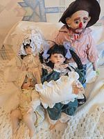 Group shot of all four porcelain and cloth dolls on blanket
