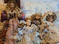 All four porcelain dolls grouped together on sofa