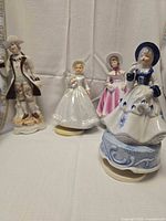 Group view of four porcelain Victorian figurines