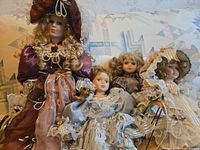 Group shot of four porcelain dolls on sofa