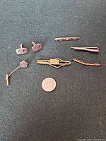 All seven accessories laid out with penny for scale