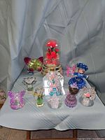 Group view of all figurines, doll and dome display on surface