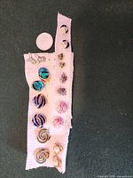Front view showing all nine pairs on cloth strip with quarter for scale