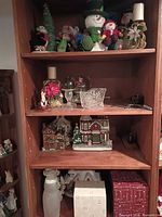 Wooden shelving with multiple Christmas decorative items across four shelves