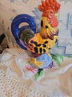 front view of multicolor ceramic rooster pitcher with tail handle