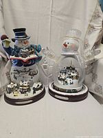 Two snowman snow globes side by side showing overall size and design
