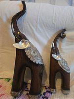 Both elephant figurines side by side displaying relative sizes and overall design