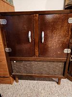 Front view of closed RCA Victor console speaker cabinet showing doors, grille, legs and finish wear