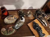 Group shot showing all resin wildlife plaques, goose figurine and Inuit figure