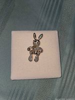 Front view of rhinestone-covered bunny brooch on display pad