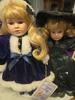 Samantha and Angelina porcelain dolls standing side by side showing outfits, tags and stands