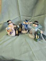 Front view of the three resin snowman figurines with lanterns