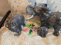 All three gray marbled ceramic elephant figurines on blanket