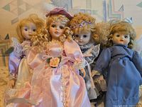 All four dolls side by side displaying outfits and size comparison