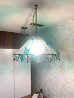 Full view of stained glass pendant light hanging from ceiling