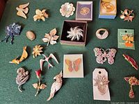 Group image of approximately 23 assorted vintage costume brooches and pins showing variety of motifs, finishes and embellishments