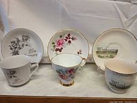 Front view of assorted plates and cups showing designs and gold trim