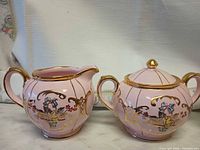 Pink floral creamer and matching lidded sugar bowl with gold trim