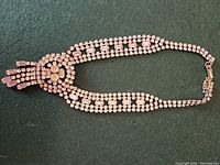 Front view of full necklace showing rhinestones, clasp and safety chain
