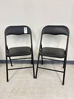 Both black folding chairs front view