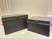 Two black metal lockboxes side by side