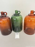 Front view of three demijohn jugs showing colors and sizes