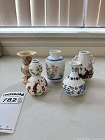 All five porcelain mini bud vases grouped